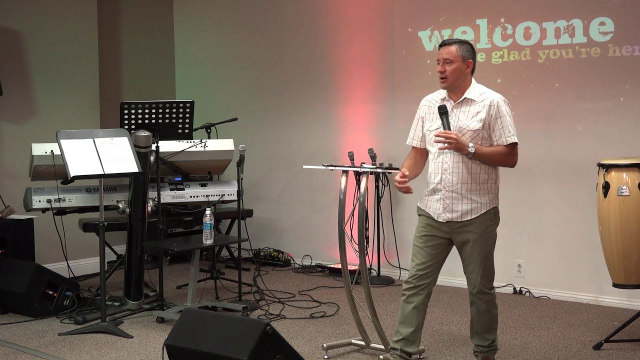 Ruslan Murin walking across the stage as he preaches into a microphone.