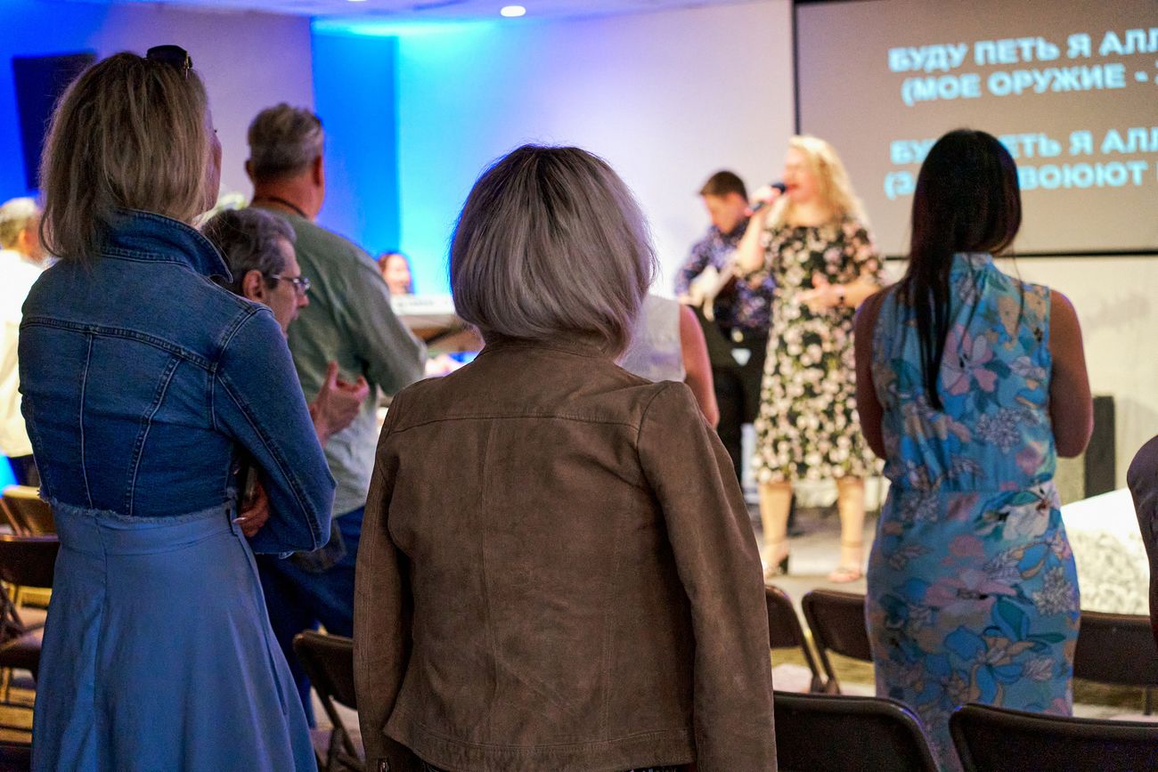 The congregation standing during worship, seen from behind