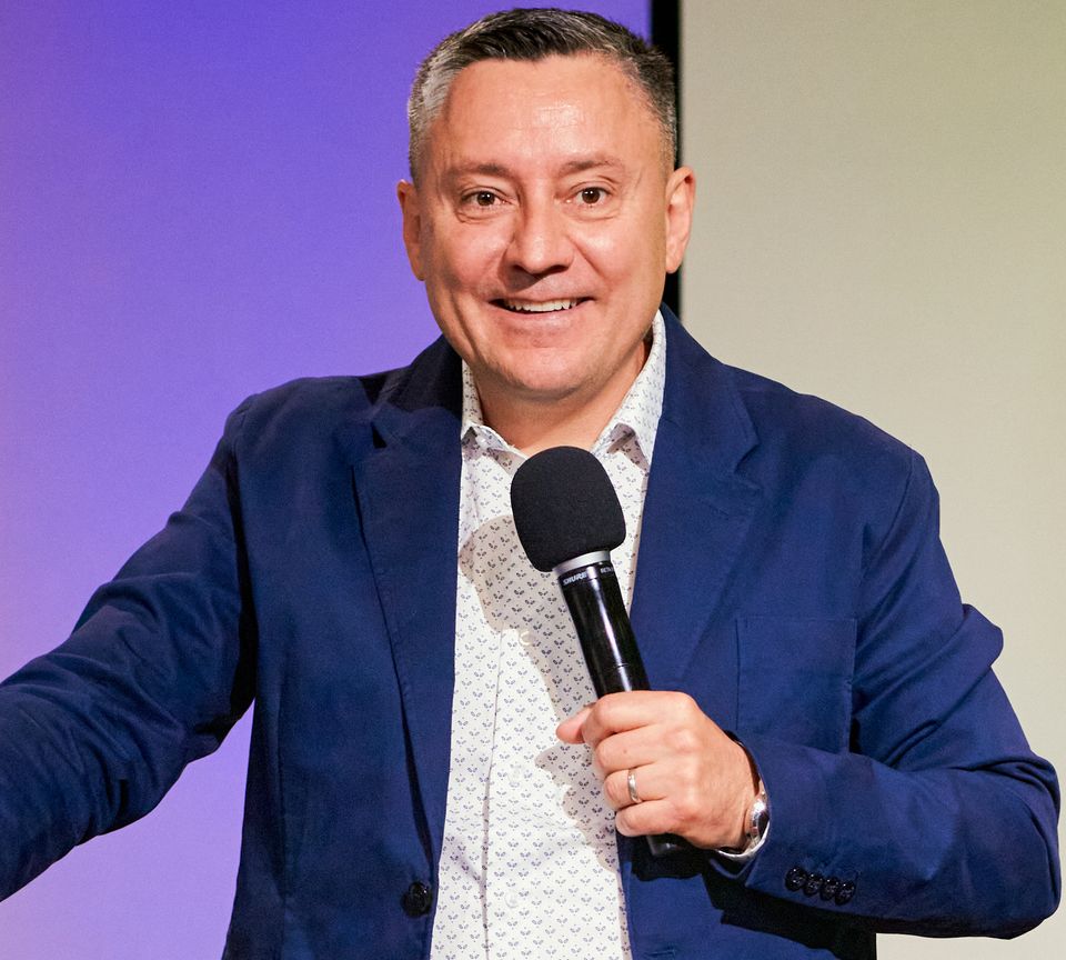 Pastor Ruslan Murin speaking into a microphone during a service