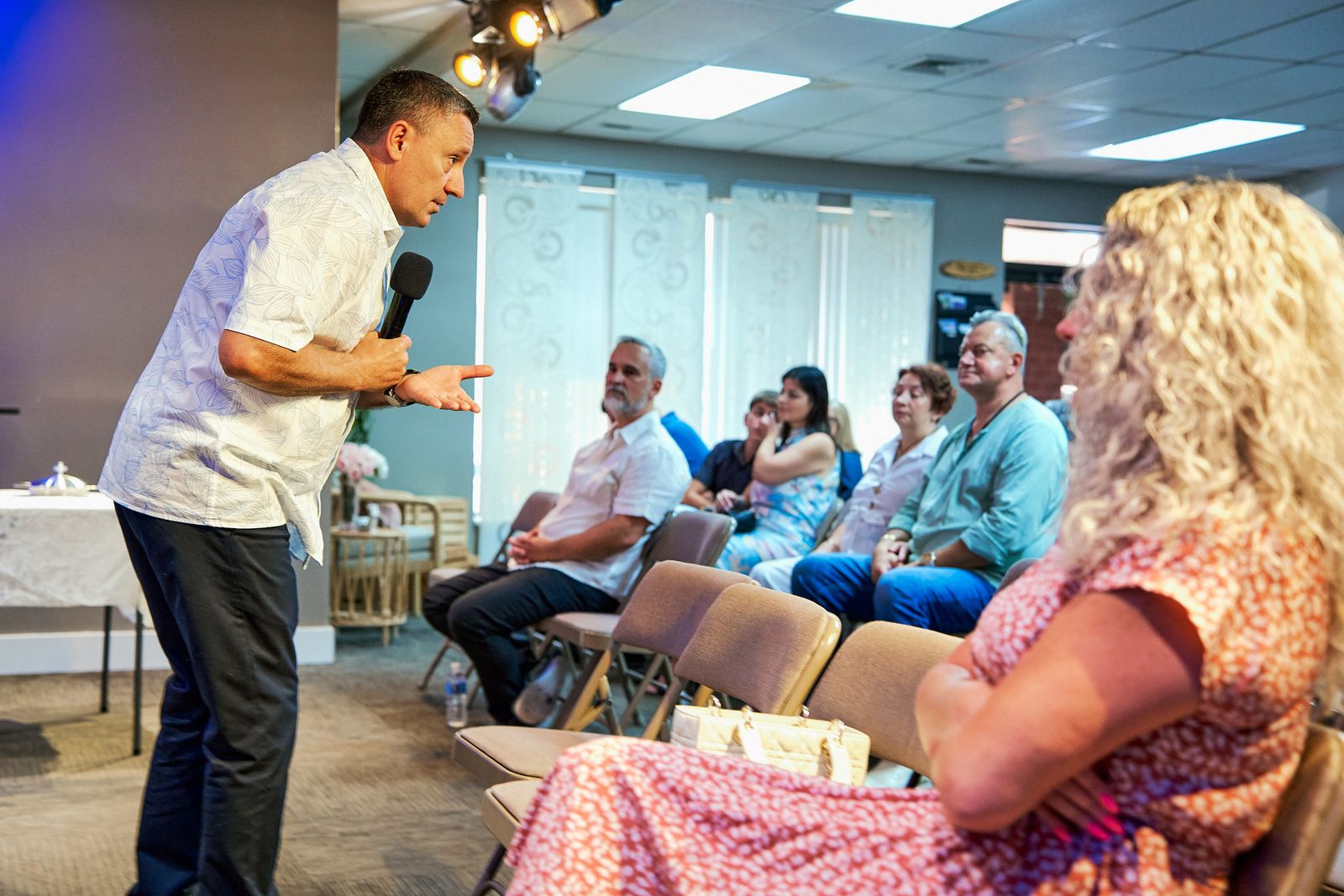 Pastor Ruslan Murin speaking to people seated in the church in daylight